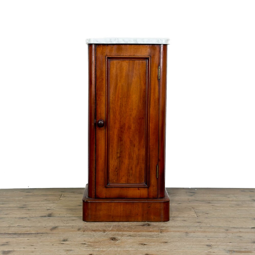 A Victorian mahogany pot cupboard featuring a single panelled door with a turned handle and a white marble top.