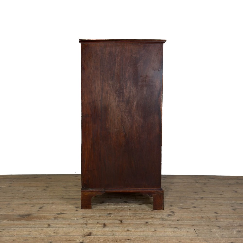A four-drawer Georgian chest of drawers crafted from dark mahogany wood featuring brass swan-neck handles and bracket feet. View III