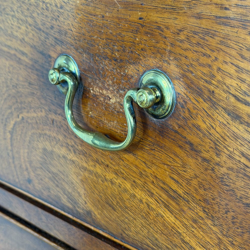 A four-drawer Georgian chest of drawers crafted from dark mahogany wood featuring brass swan-neck handles and bracket feet. View IV