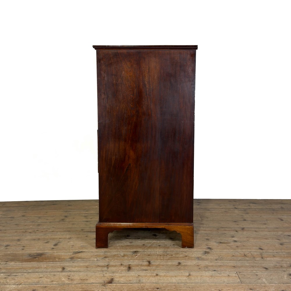 A four-drawer Georgian chest of drawers crafted from dark mahogany wood featuring brass swan-neck handles and bracket feet. View VI
