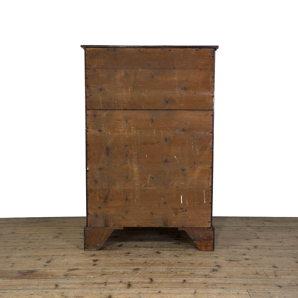 A four-drawer Georgian chest of drawers crafted from dark mahogany wood featuring brass swan-neck handles and bracket feet. View VII