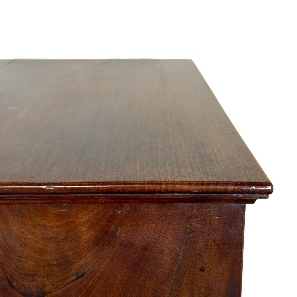 A four-drawer Georgian chest of drawers crafted from dark mahogany wood featuring brass swan-neck handles and bracket feet. View VIII