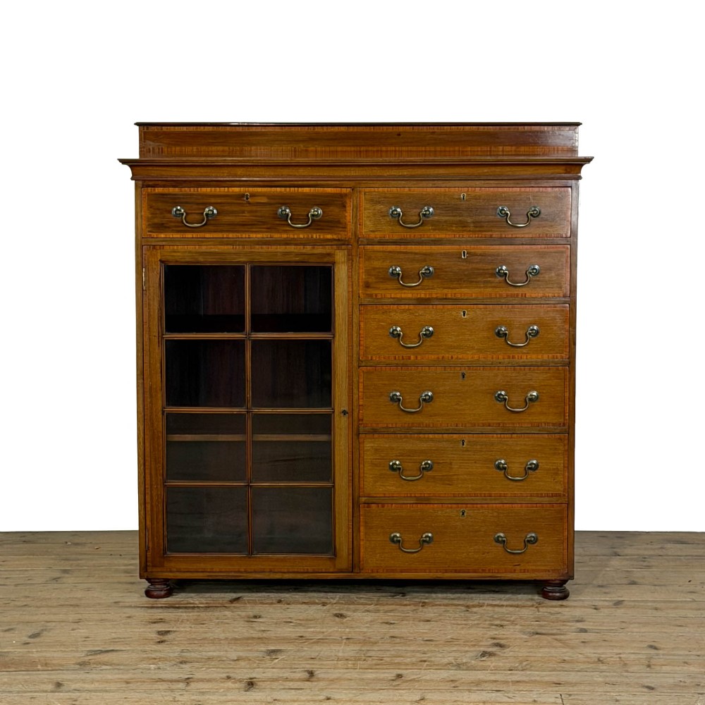 An Edwardian mahogany cabinet featuring an eight-pane glazed door on the left beside a vertical bank of six drawers with brass handles.