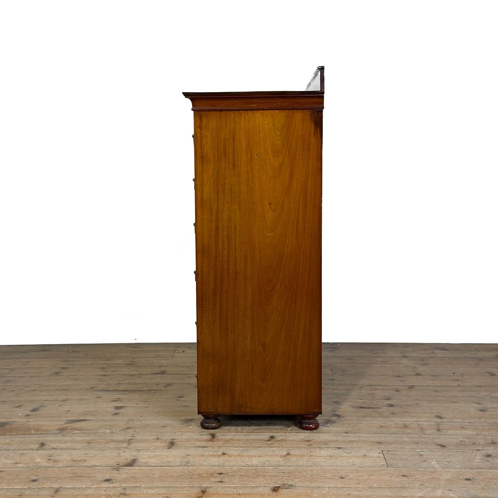 An Edwardian mahogany cabinet featuring an eight-pane glazed door on the left beside a vertical bank of six drawers with brass handles. View VII