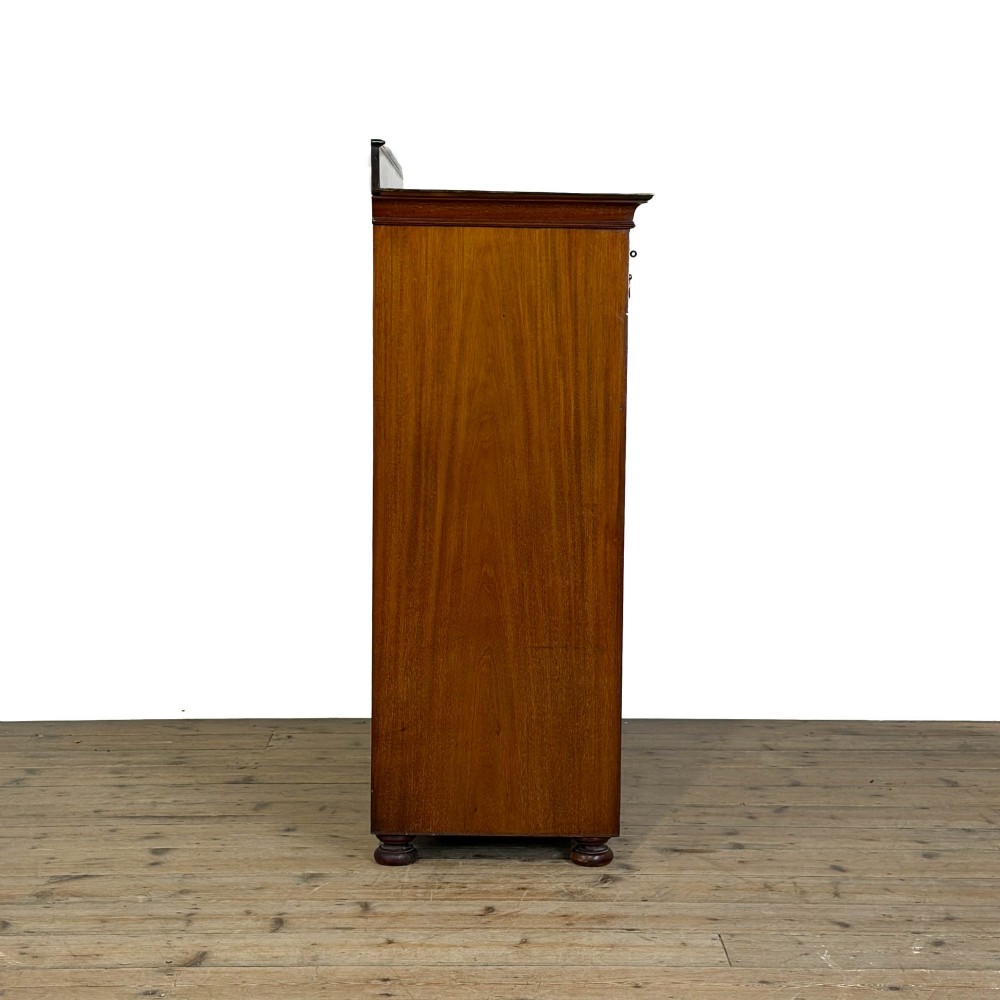 An Edwardian mahogany cabinet featuring an eight-pane glazed door on the left beside a vertical bank of six drawers with brass handles. View VIII