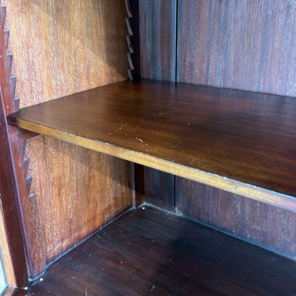 An Edwardian mahogany cabinet featuring an eight-pane glazed door on the left beside a vertical bank of six drawers with brass handles. View X