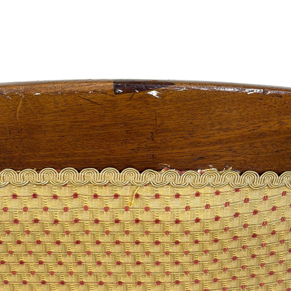 A Victorian upholstered armchair featuring a button-backed yellow patterned fabric seat and a carved mahogany frame with brass castors. View VII