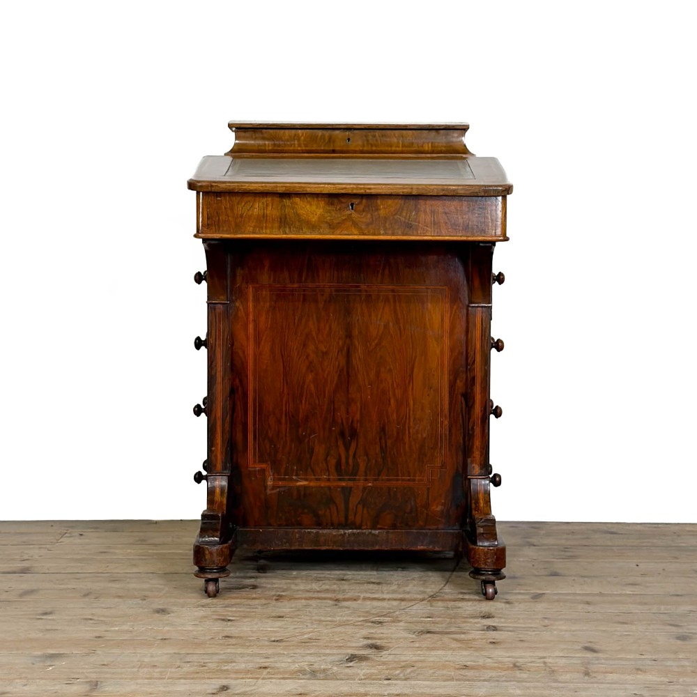 An antique Victorian walnut Davenport desk featuring a slanted leather-lined writing surface, an upper stationery compartment, and four drawers on the side. View V