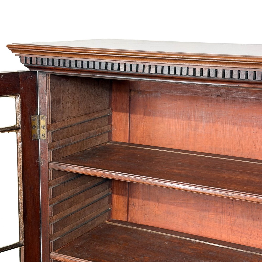 A 19th-century dark mahogany low bookcase featuring two glazed doors with geometric astragal glazing bars, dentil moulding at the top cornice, and bracket feet. View II