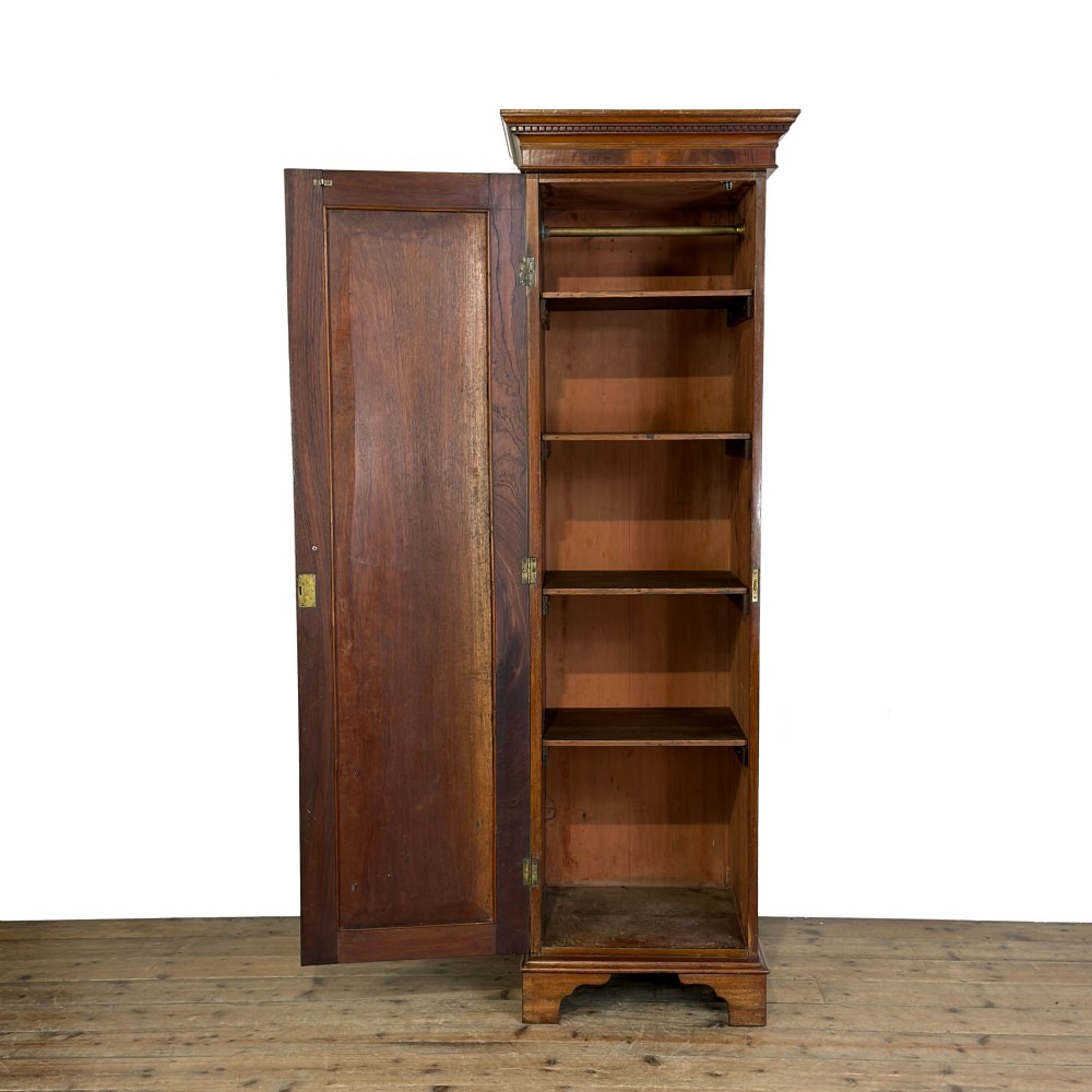 A tall single door mahogany wardrobe featuring a moulded cornice, flame mahogany veneer door panel, and bracket feet. View II