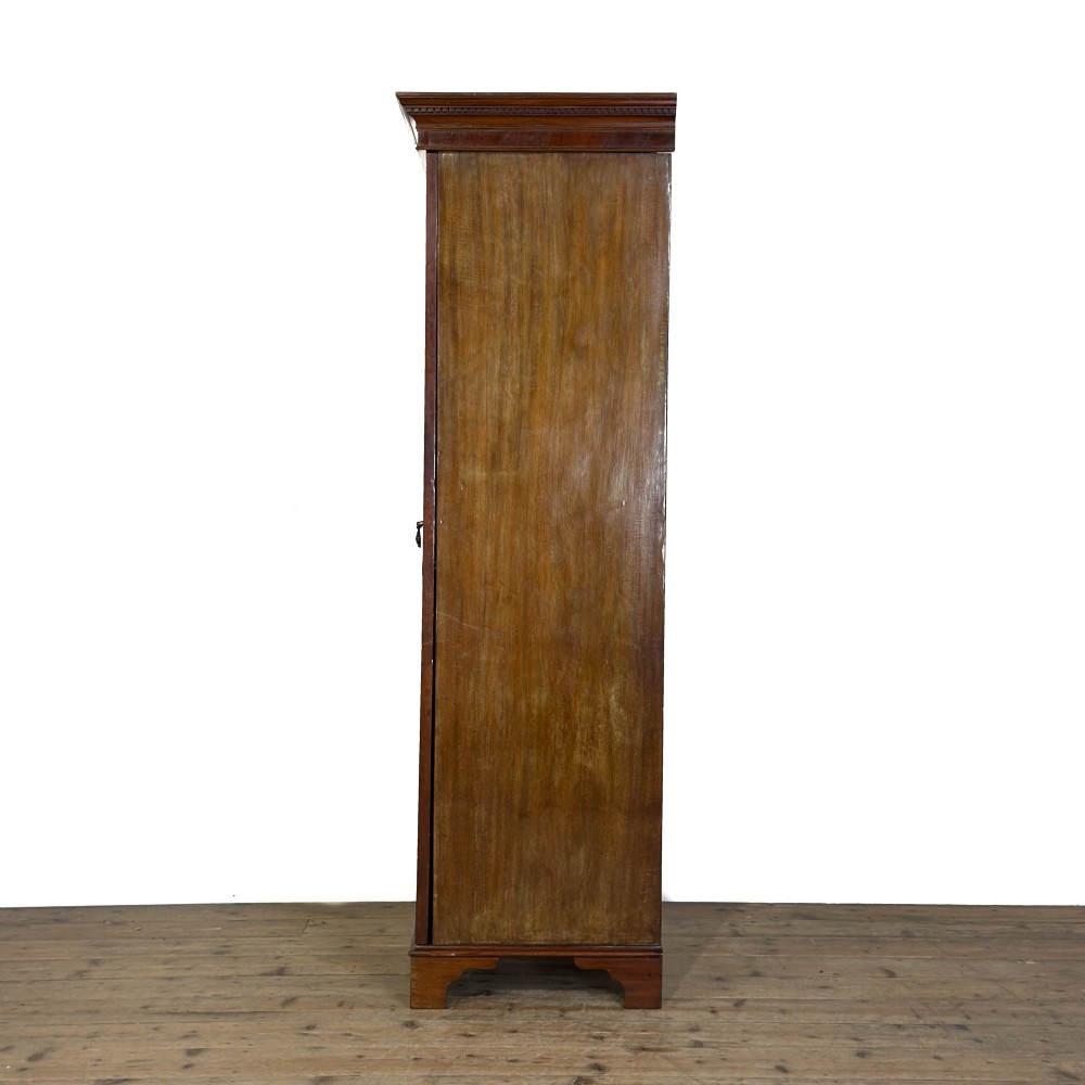 A tall single door mahogany wardrobe featuring a moulded cornice, flame mahogany veneer door panel, and bracket feet. View III