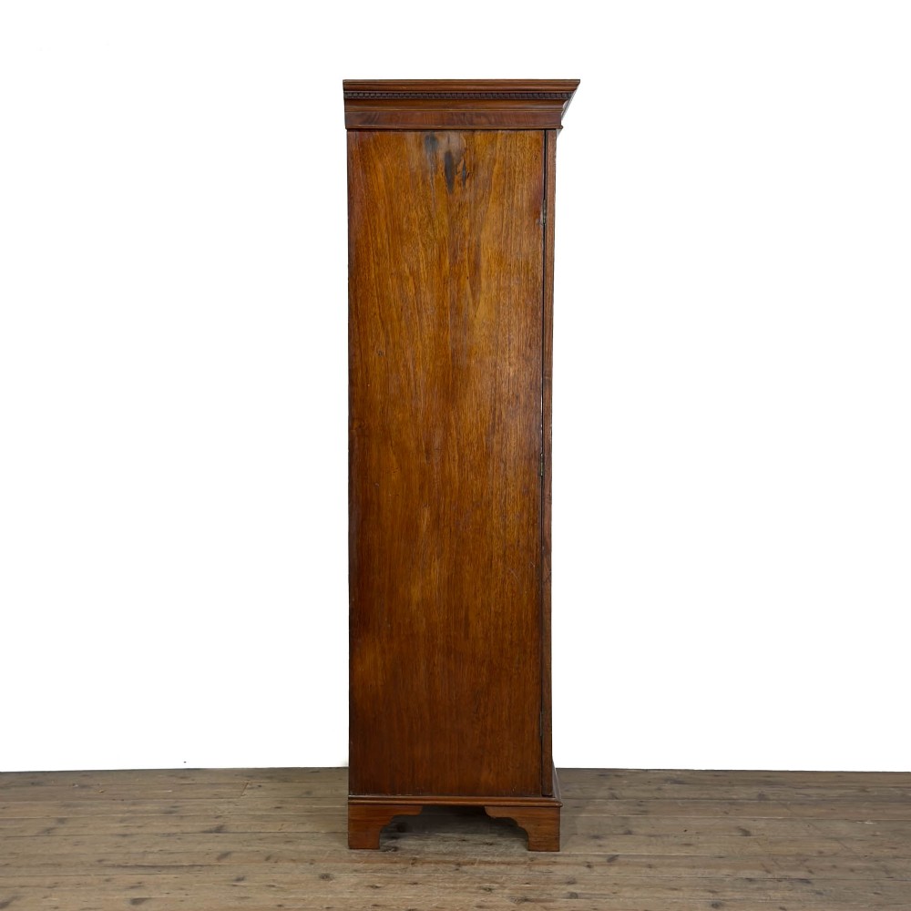 A tall single door mahogany wardrobe featuring a moulded cornice, flame mahogany veneer door panel, and bracket feet. View IX
