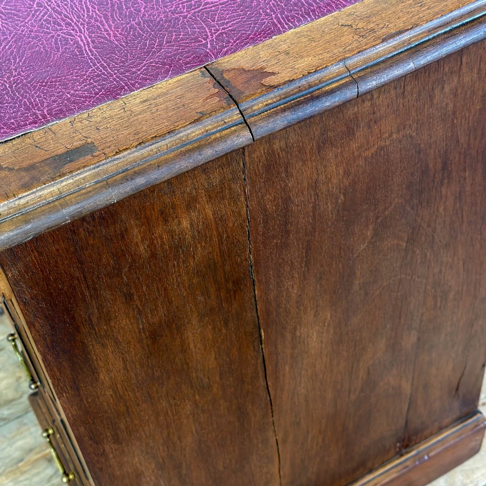 An Edwardian timber kneehole desk featuring a central drawer flanked by twin pedestals with brass handles and a rectangular top. View IV