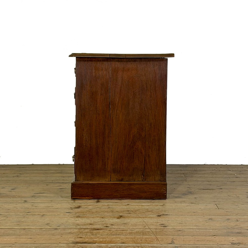 An Edwardian timber kneehole desk featuring a central drawer flanked by twin pedestals with brass handles and a rectangular top. View V