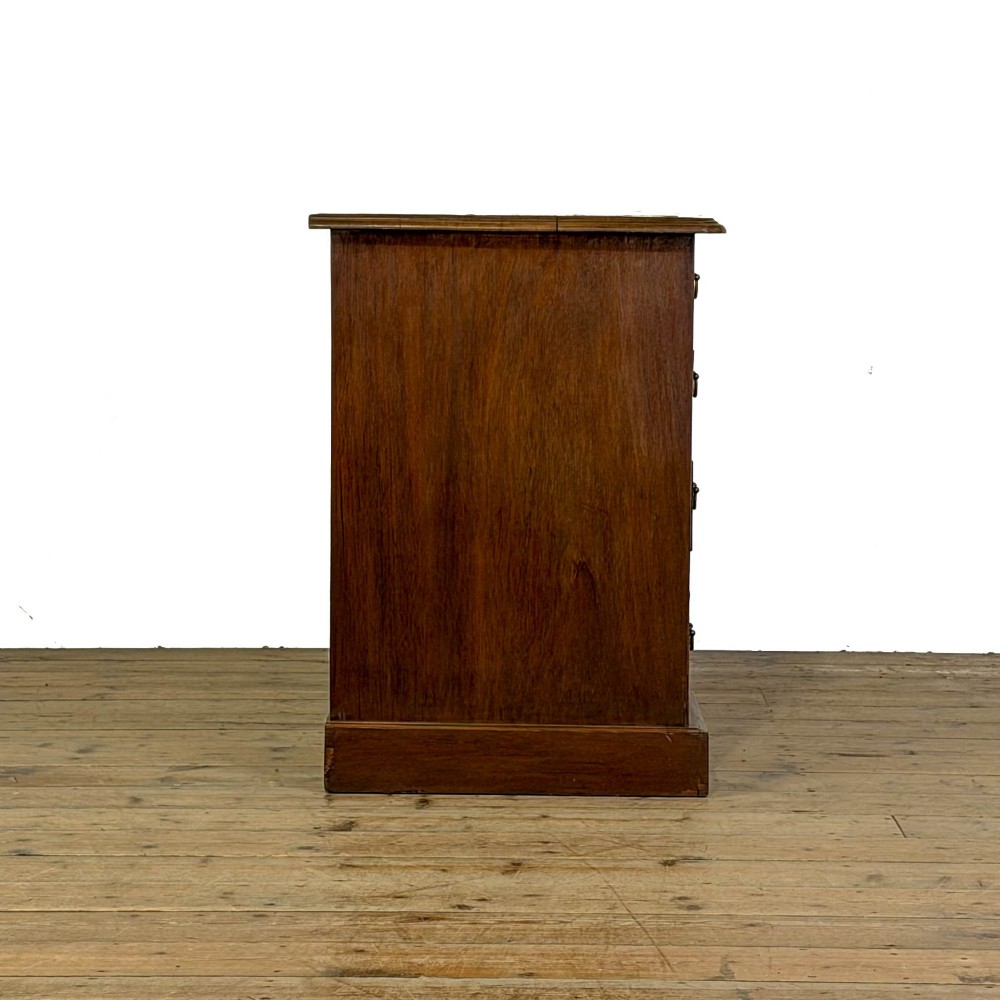 An Edwardian timber kneehole desk featuring a central drawer flanked by twin pedestals with brass handles and a rectangular top. View VII