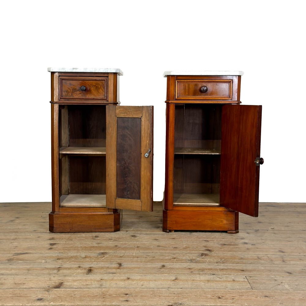 A matching pair of French Louis Philippe style walnut bedside cabinets with white marble tops, upper drawers, lower cupboard doors, and plinth bases. View II