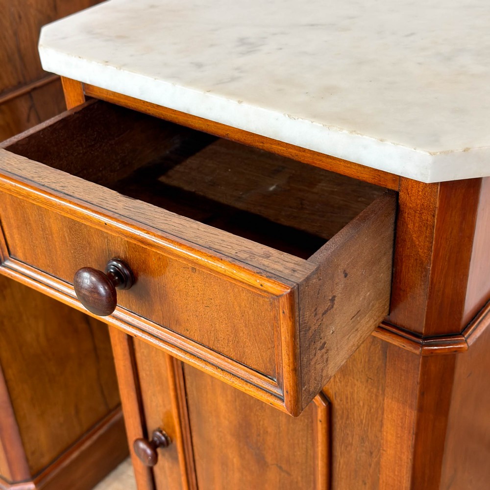 A matching pair of French Louis Philippe style walnut bedside cabinets with white marble tops, upper drawers, lower cupboard doors, and plinth bases. View III