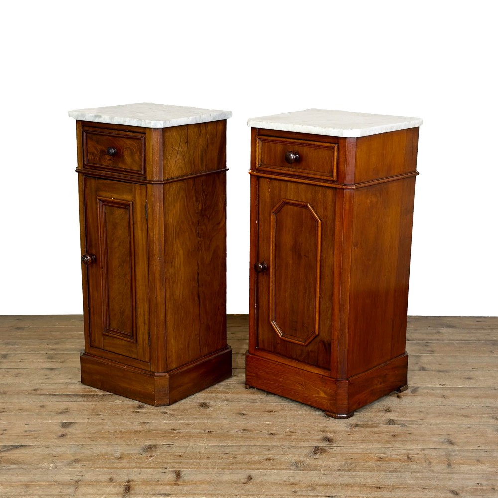 A matching pair of French Louis Philippe style walnut bedside cabinets with white marble tops, upper drawers, lower cupboard doors, and plinth bases. View IV