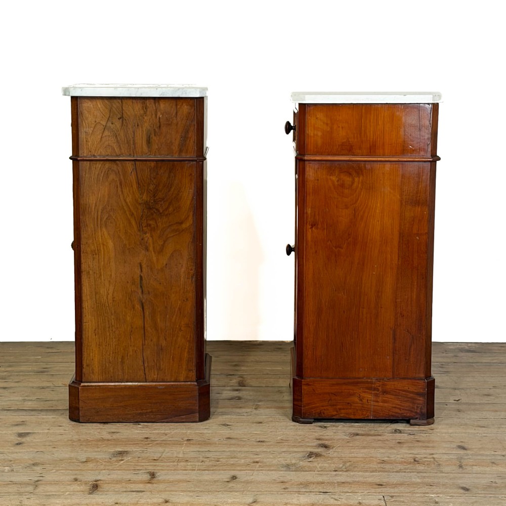 A matching pair of French Louis Philippe style walnut bedside cabinets with white marble tops, upper drawers, lower cupboard doors, and plinth bases. View VI