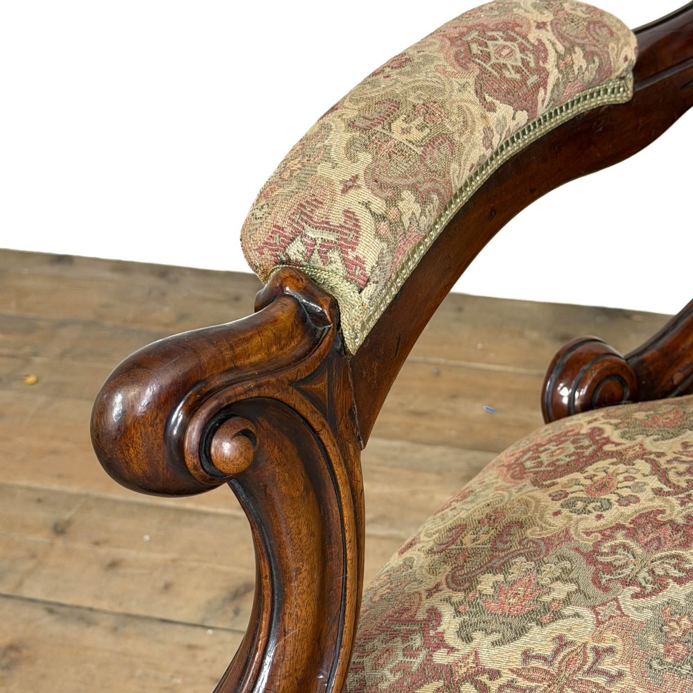 Victorian carved mahogany armchair with deep button-backed floral tapestry upholstery, curved armrests, and cabriole legs on brass castors. View IX