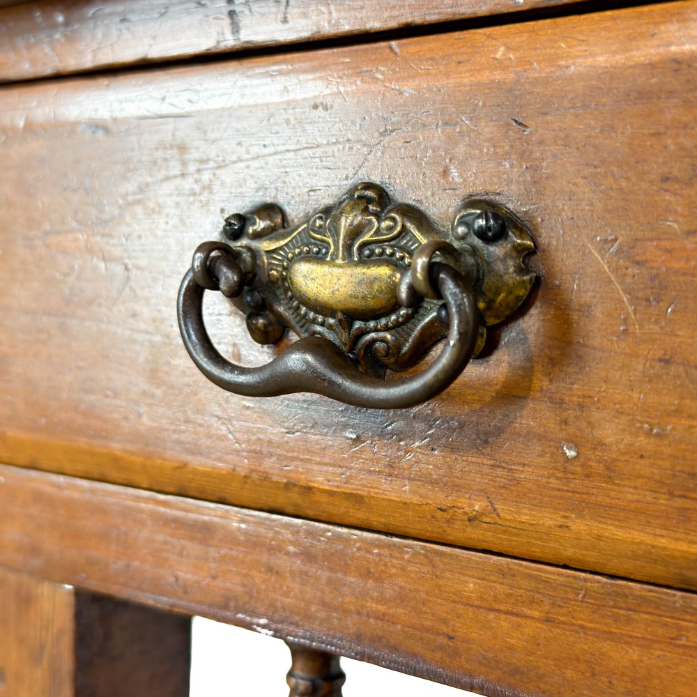 An Edwardian wooden washstand with a carved splashback housing floral glazed tiles, a single drawer with drop handles, turned legs, and an undertier shelf. View III