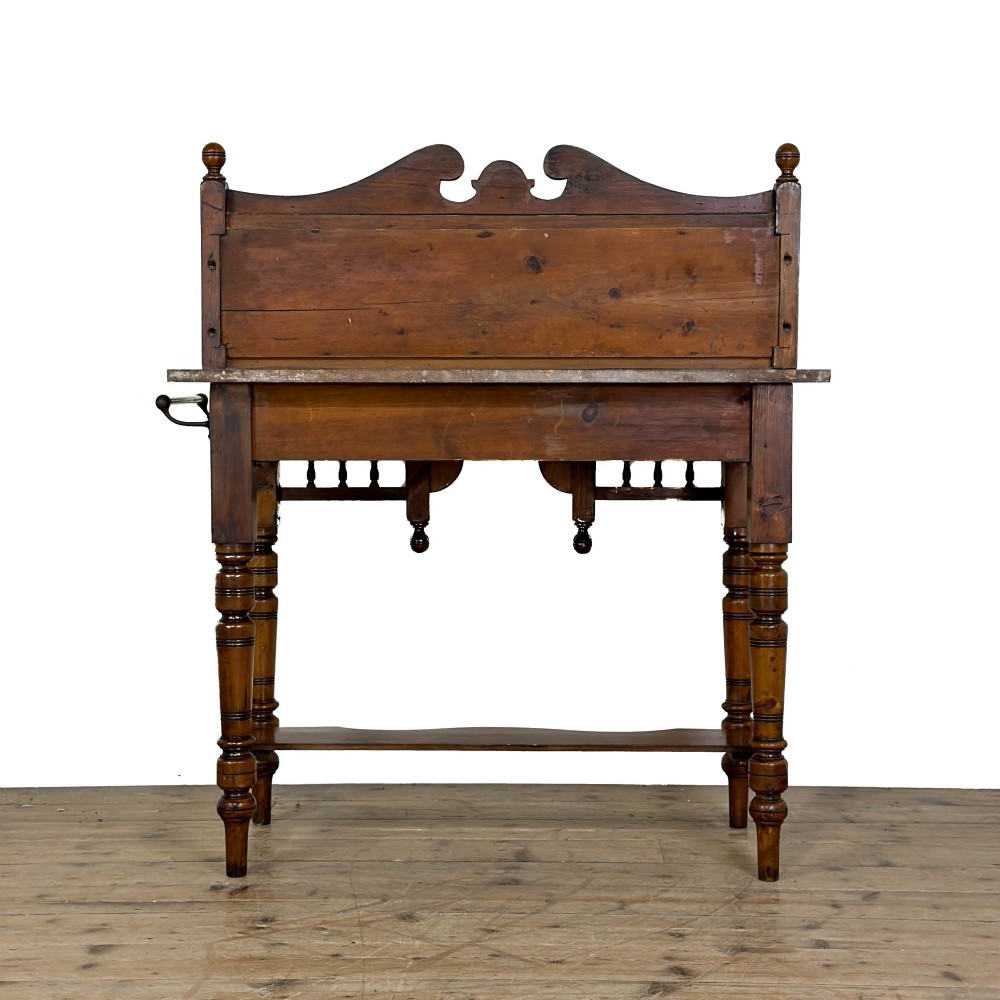 An Edwardian wooden washstand with a carved splashback housing floral glazed tiles, a single drawer with drop handles, turned legs, and an undertier shelf. View VIII
