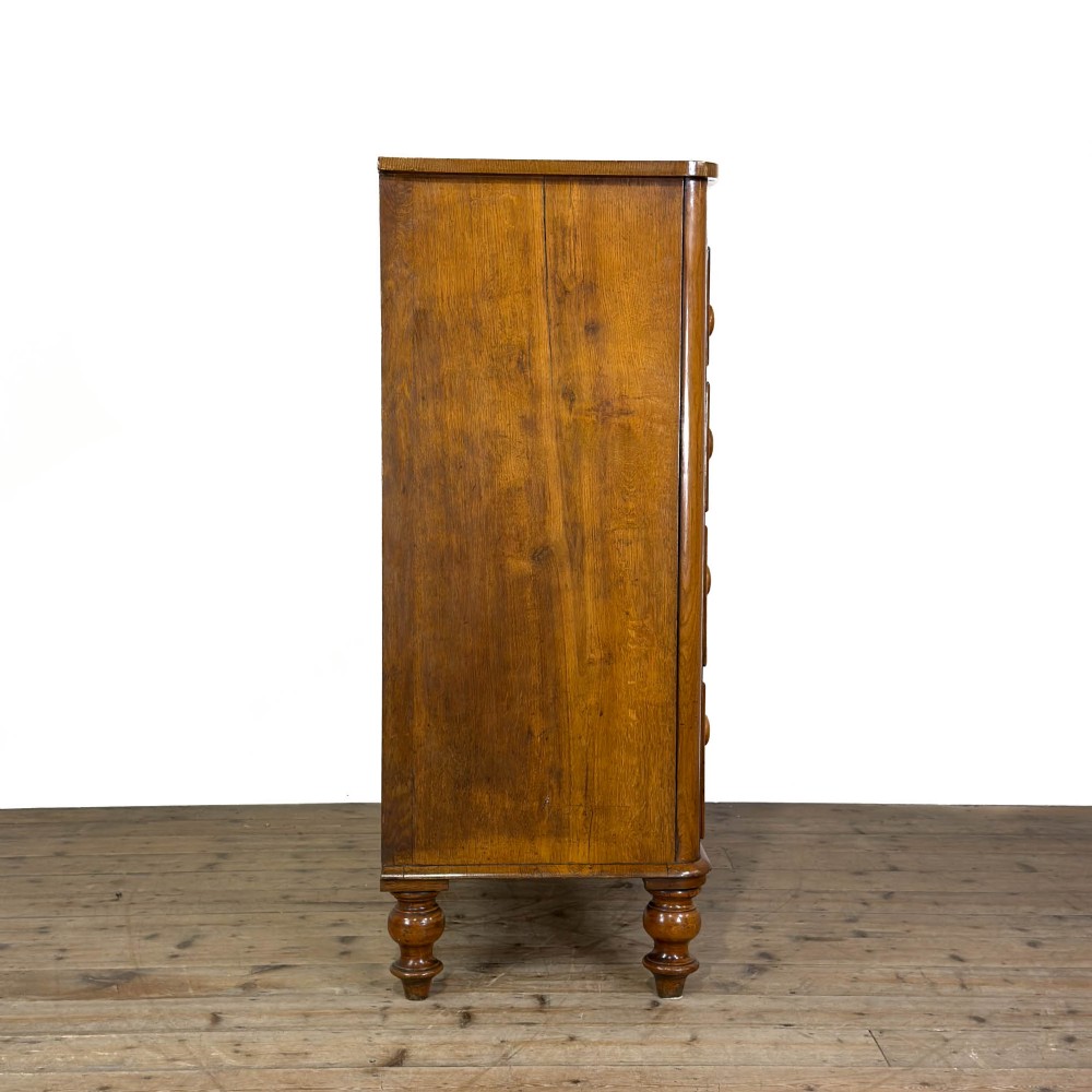 A Victorian light oak chest of drawers featuring a two-over-three drawer configuration with turned wooden knobs and turned feet. View III