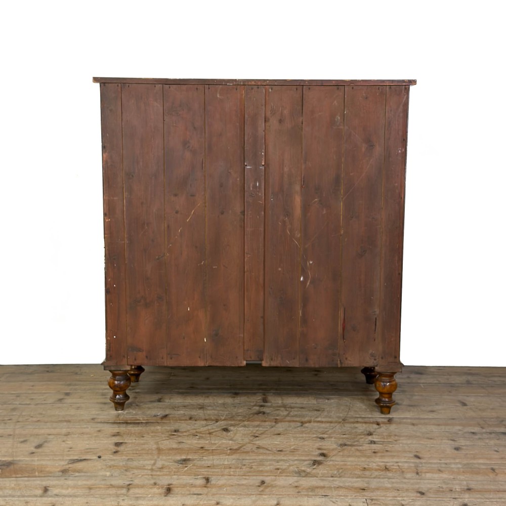 A Victorian light oak chest of drawers featuring a two-over-three drawer configuration with turned wooden knobs and turned feet. View VII