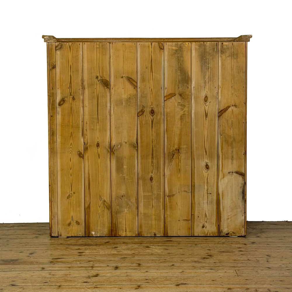 A large vintage pine cabinet featuring twin glazed doors with multiple glass panes and dark wooden knob handles. View VIII