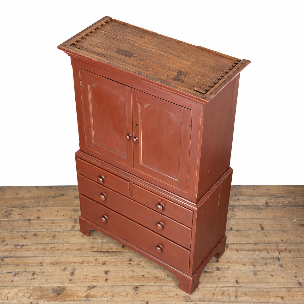 A tall Victorian painted pine housekeepers cupboard in a terracotta red finish, featuring a double-door upper cabinet over two short and two long drawers. View II