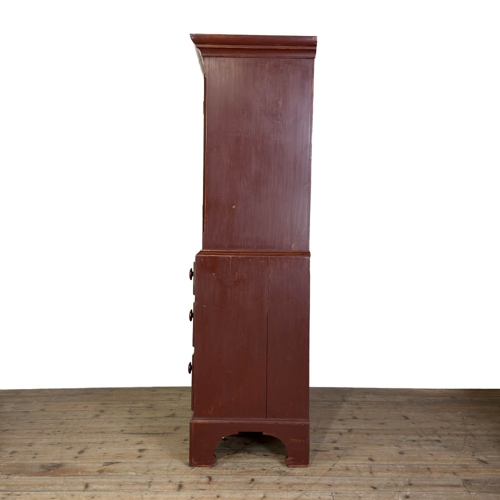 A tall Victorian painted pine housekeepers cupboard in a terracotta red finish, featuring a double-door upper cabinet over two short and two long drawers. View III