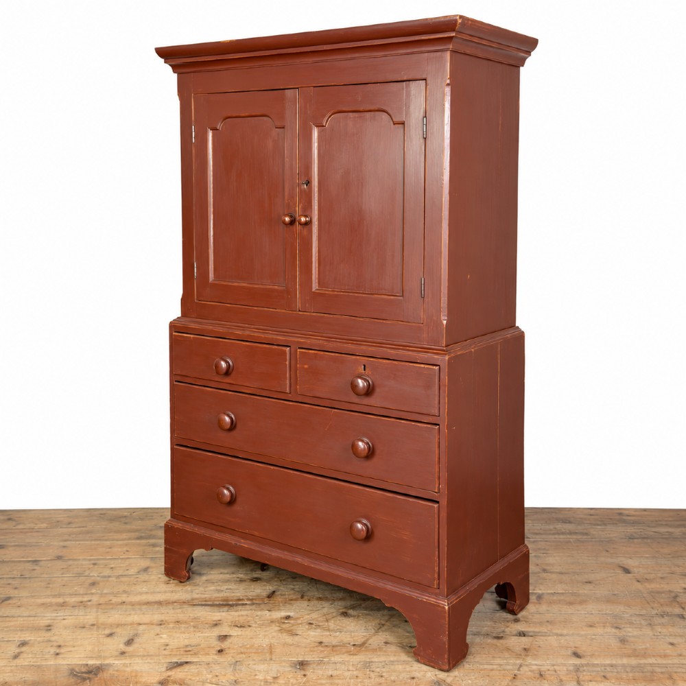 A tall Victorian painted pine housekeepers cupboard in a terracotta red finish, featuring a double-door upper cabinet over two short and two long drawers. View V