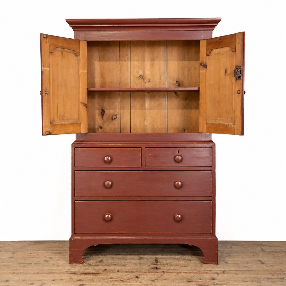 A tall Victorian painted pine housekeepers cupboard in a terracotta red finish, featuring a double-door upper cabinet over two short and two long drawers. View VI