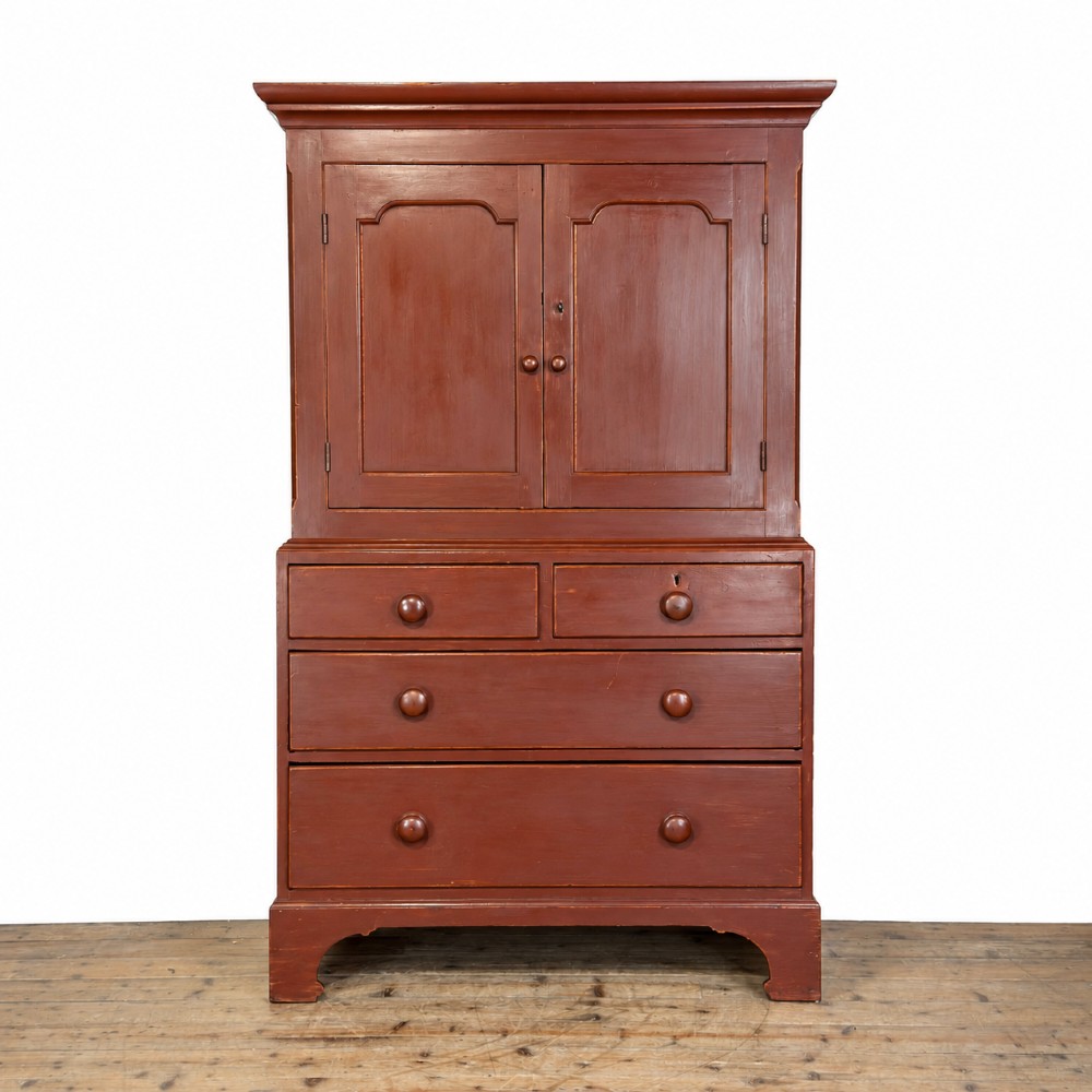 A tall Victorian painted pine housekeepers cupboard in a terracotta red finish, featuring a double-door upper cabinet over two short and two long drawers. View IX