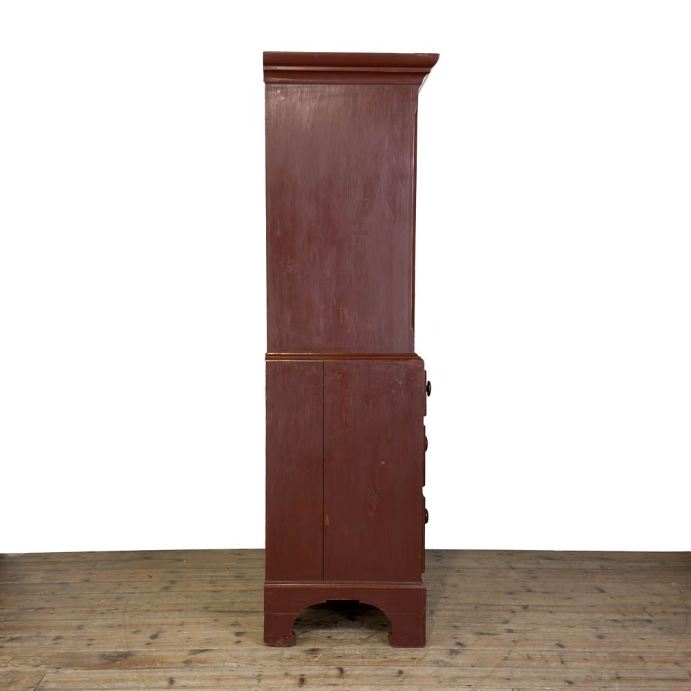 A tall Victorian painted pine housekeepers cupboard in a terracotta red finish, featuring a double-door upper cabinet over two short and two long drawers. View XII