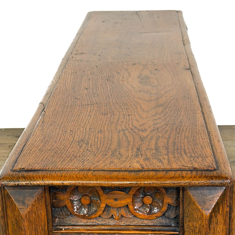 A long Victorian carved oak hall bench featuring a detailed floral rosette frieze, acorn drop pendants, and four turned legs on a light timber floor. View VIII