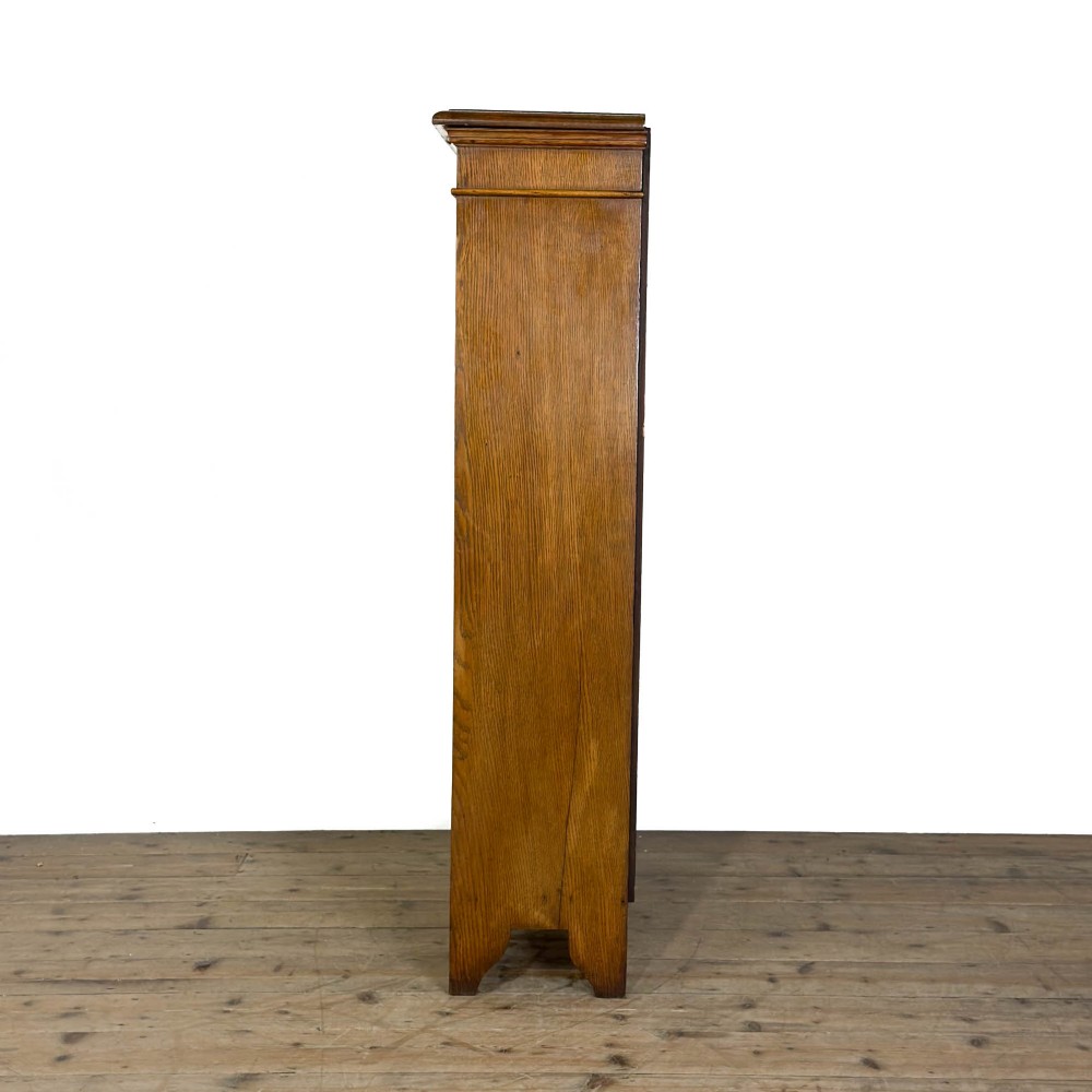 An open antique oak bookcase featuring four wooden shelves, a upper moulded cornice, vertical pine backboards, and shaped bracket feet. View VIII