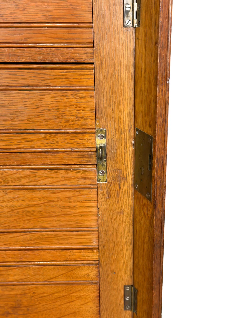 A tall late Victorian oak Wellington chest featuring seven drawers with brass drop handles, fluted side pilasters, and turned feet. View V