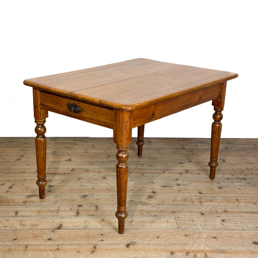 A Victorian warm brown pine kitchen table featuring turned legs and a single drawer at one end.