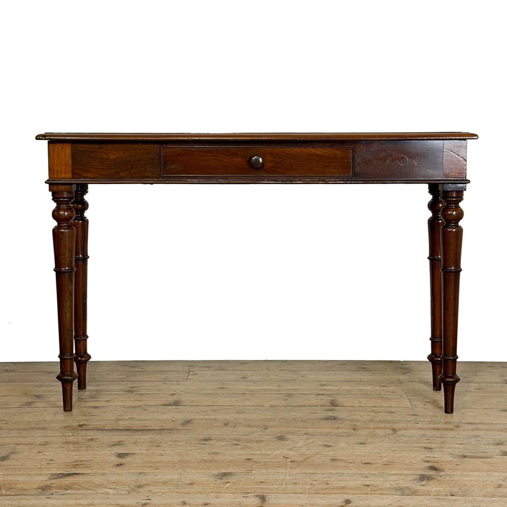 An antique dark mahogany hall table featuring a single central drawer with a round knob handle and four slender turned legs.