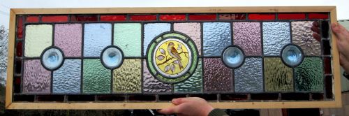 A Colourful Vibrant Stained Glass Window with a Painted Bird Centre