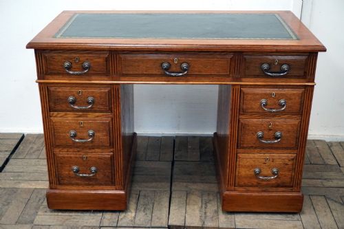 A Small Clean Oak Pedastal Desk with 9 Drawers