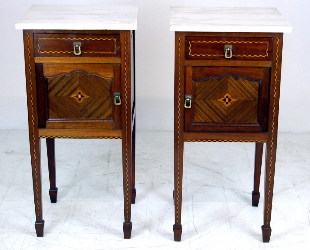 An inlaid mahogany pair of French marble top bedside cabinets