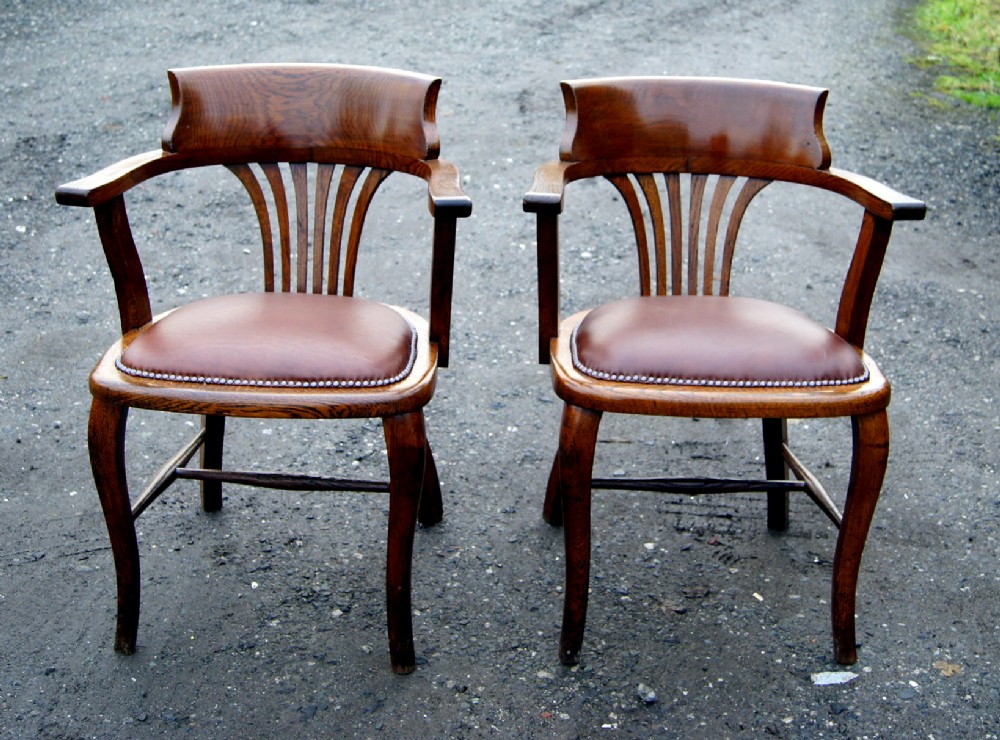 A matched pair of good antique open arm office chairs