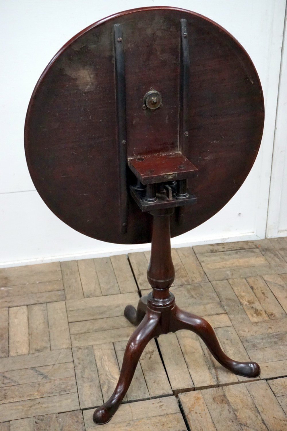A Georgian mahogany tilt-top table featuring a circular top over a turned central stem and tripod cabriole legs with pad feet. View IV