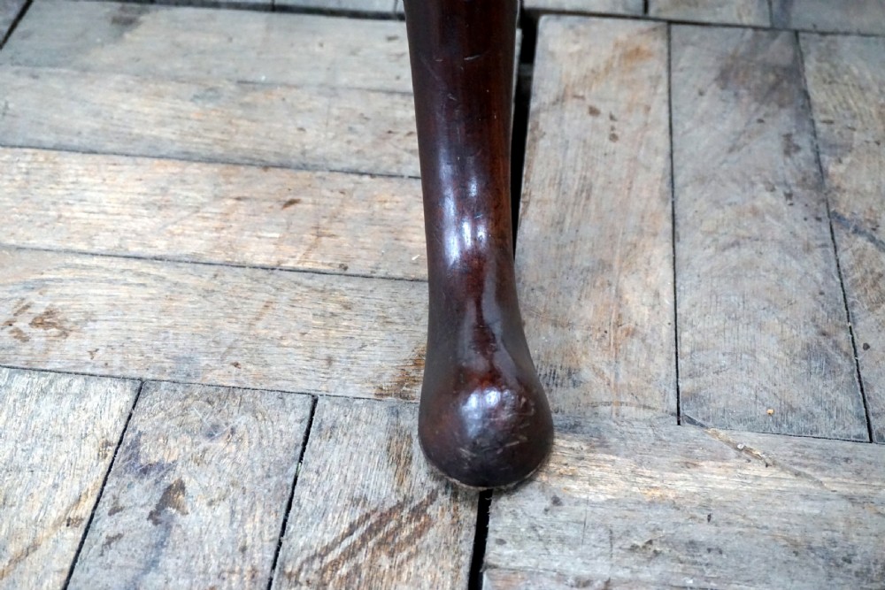 A Georgian mahogany tilt-top table featuring a circular top over a turned central stem and tripod cabriole legs with pad feet. View VII