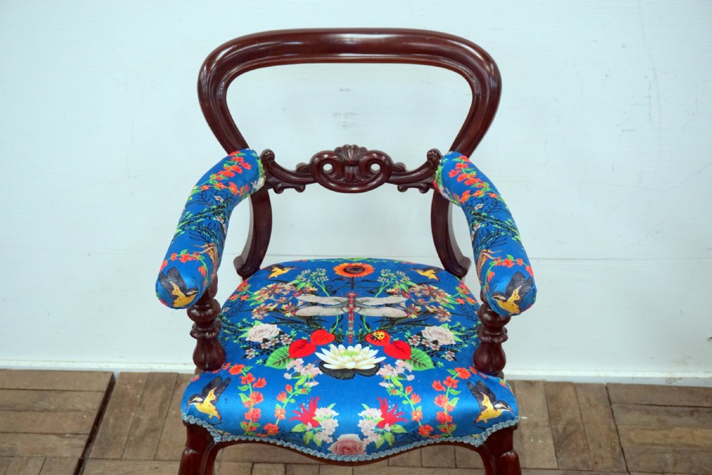 A Victorian mahogany armchair with carved scrollwork, padded armrests, cabriole legs, and vibrant blue upholstery featuring botanical floral and dragonfly patterns. View II