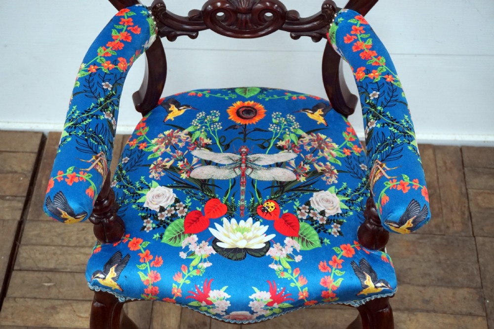 A Victorian mahogany armchair with carved scrollwork, padded armrests, cabriole legs, and vibrant blue upholstery featuring botanical floral and dragonfly patterns. View III