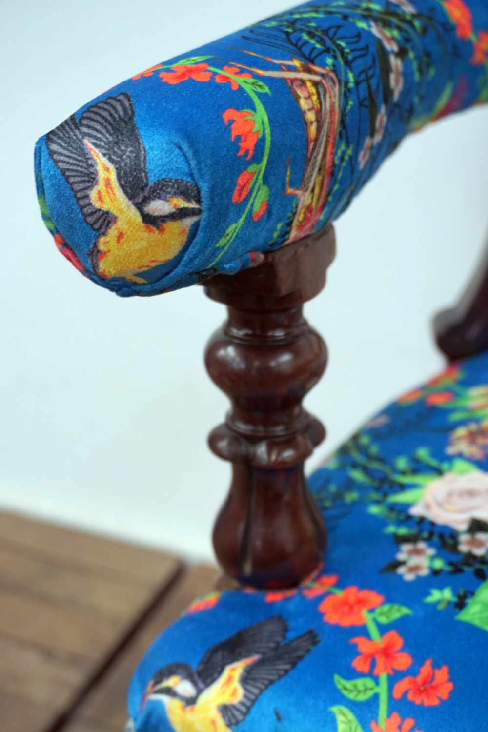 A Victorian mahogany armchair with carved scrollwork, padded armrests, cabriole legs, and vibrant blue upholstery featuring botanical floral and dragonfly patterns. View V