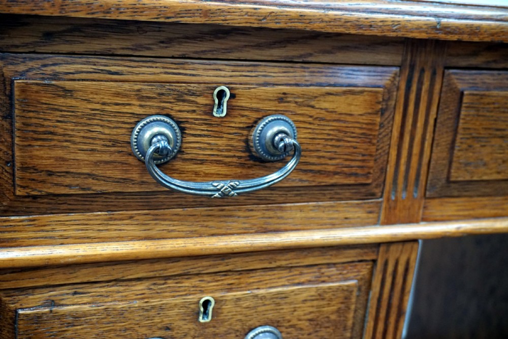 A small clean oak pedastal desk with 9 drawers View III